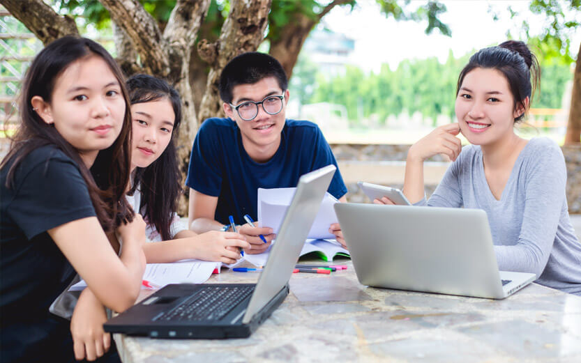 four teens studying outdoors