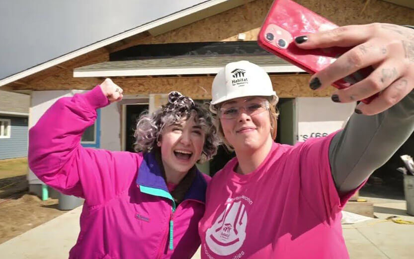 two women volunteers in pink taking a selfie