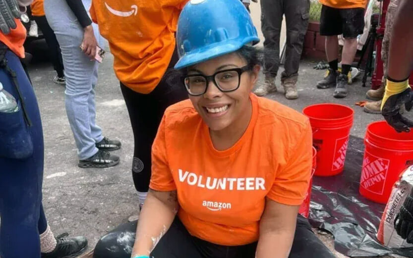 a volunteer wearing an orange shirt and blue hard hat