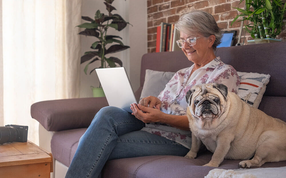 smiling elderly woman at home working with laptop