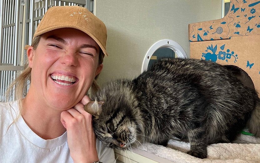 Person petting a cat while smiling
