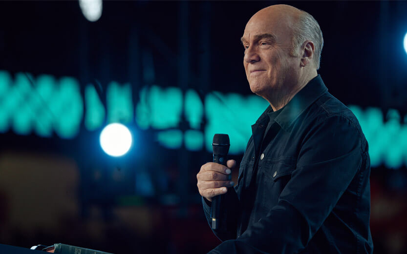 Pastor Greg Laurie profile holding a microphone