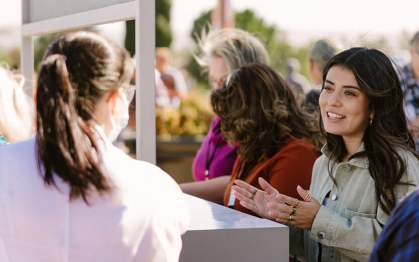 woman at a welcome booth in front of church