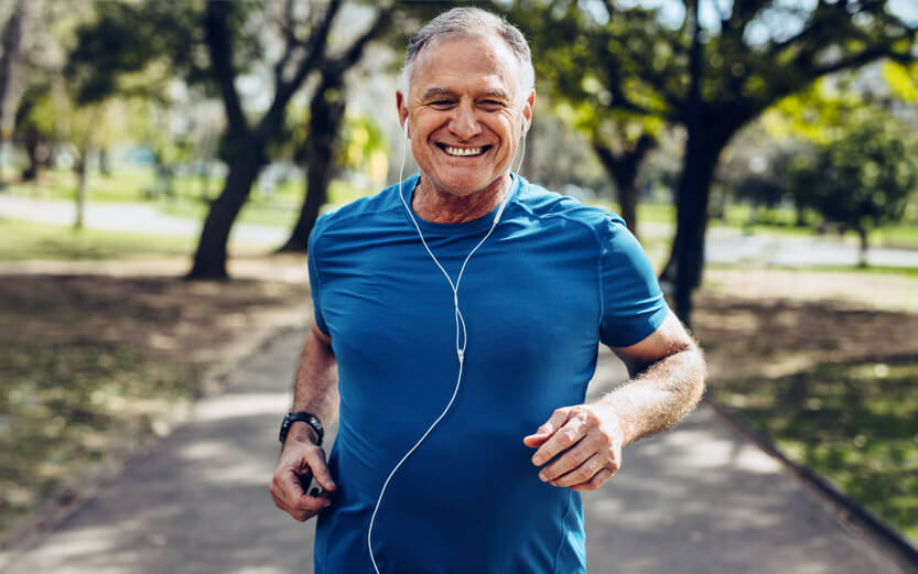 older man running and listening with earbuds