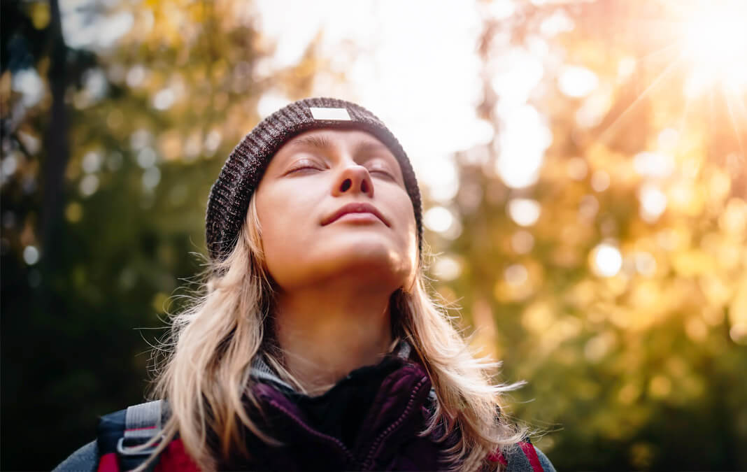 woman outdoors taking in the sun and air