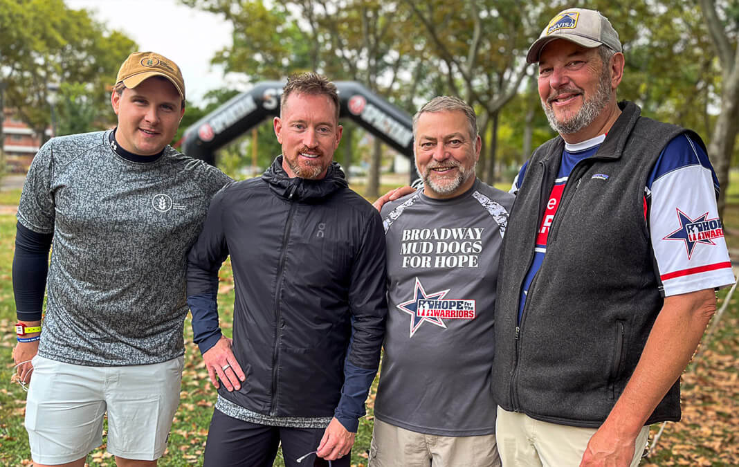group of four men smiling