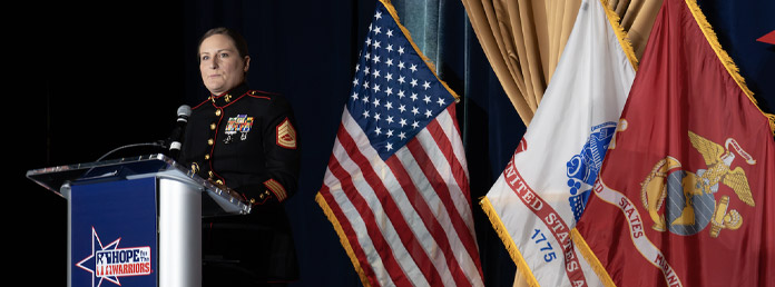 military woman speaking at podium