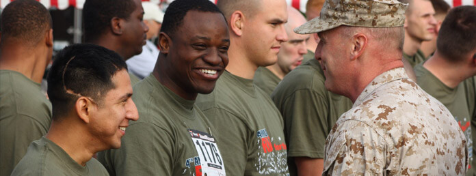 military men in green t-shirts smiling