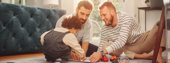 Loving LGBTQ Family Playing with Toys with Adorable Baby Boy at Home on Living Room Floor. Cheerful Gay Couple Nurturing a Child. Concept of Diverse Childhood, New Life, Parenthood.