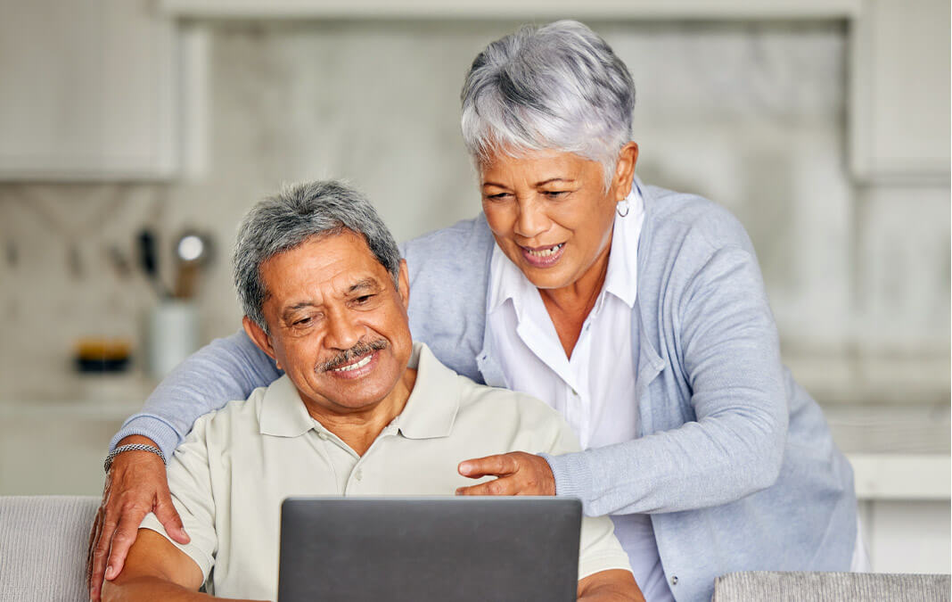 senior couple at a computer in the kitchen