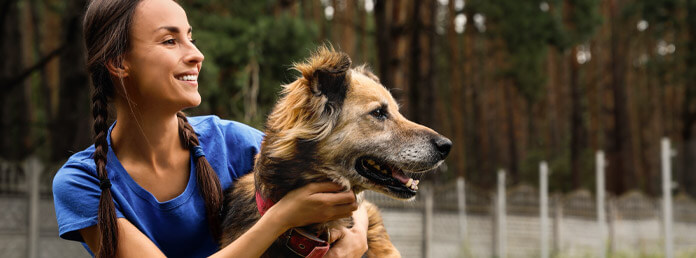 a shelter volunteer hugging a dog