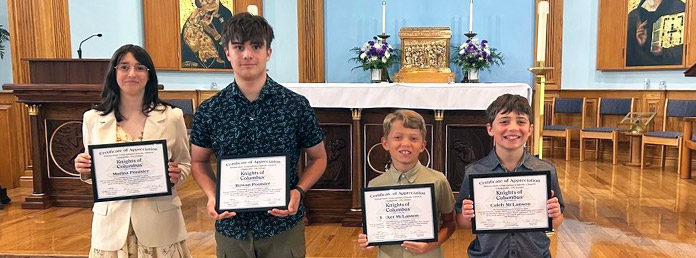four young people holding certificates
