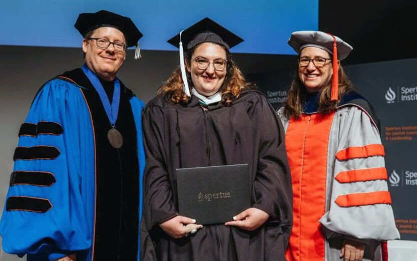 a scholarship recipient at graduation flanked by two college leaders