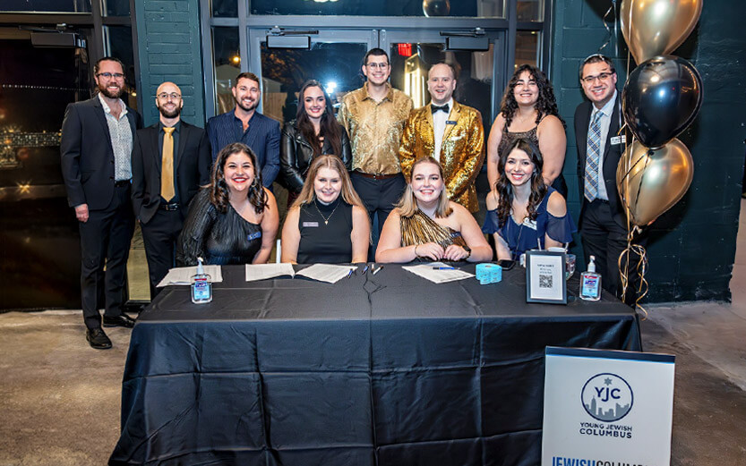 a group of young adults at a formal event smiling