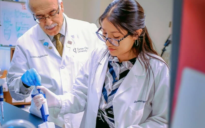 a professor helping a student with a pipette