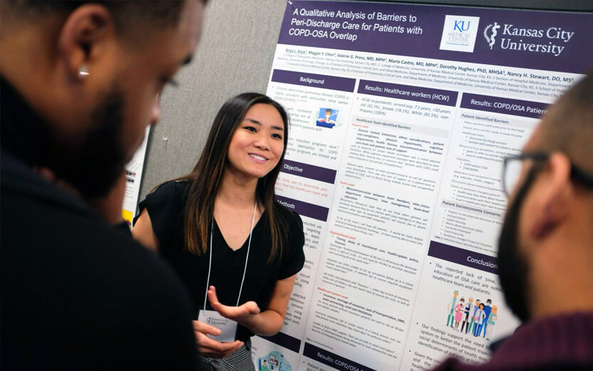 a student presenting her research poster