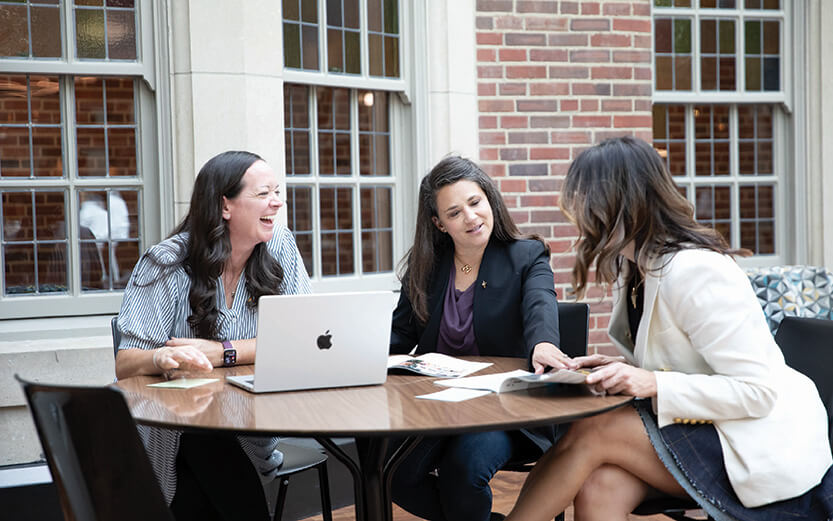 People sitting around a table with notes and a laptop