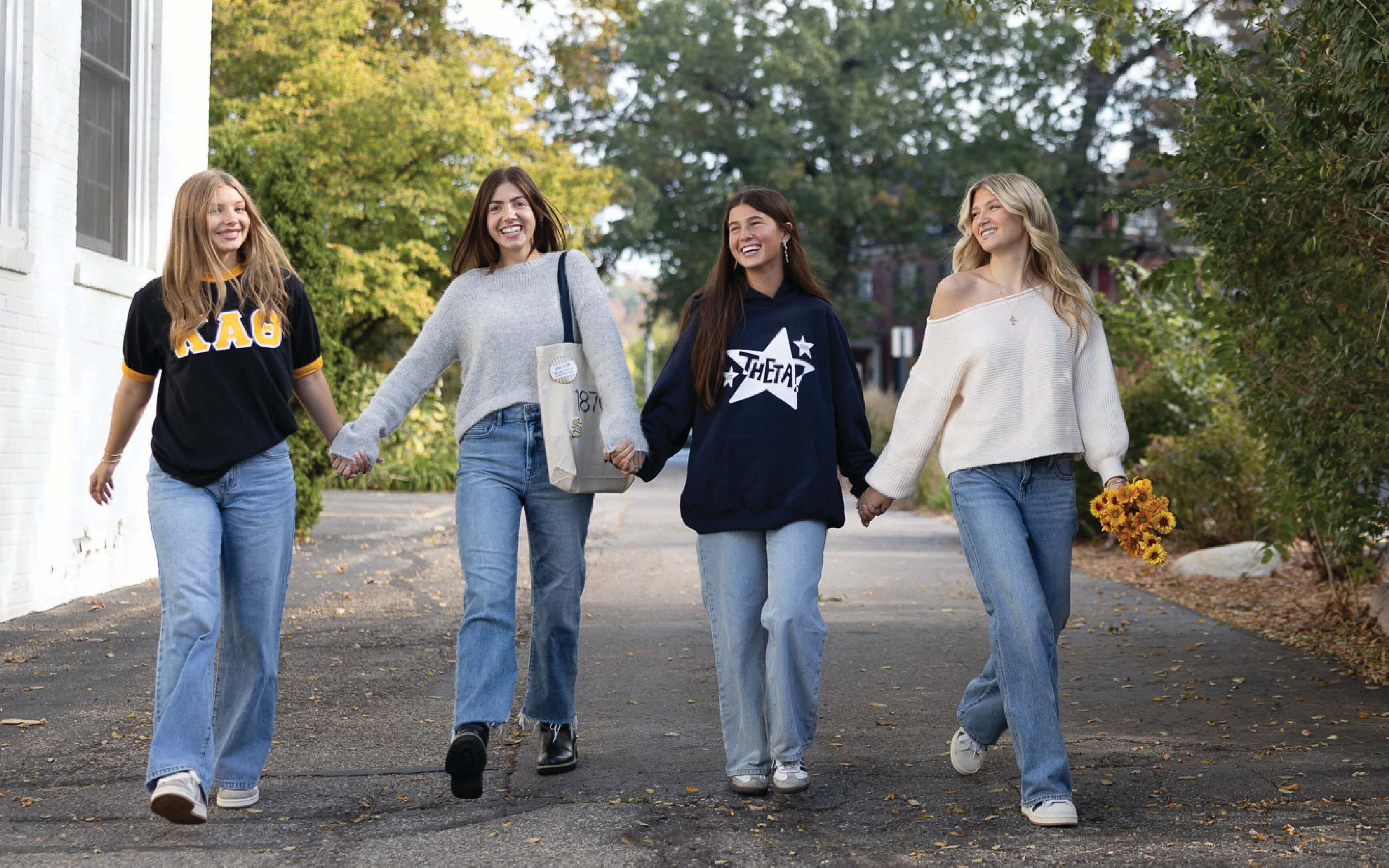 Four Kappa Alpha Theta sisters walking holding hands