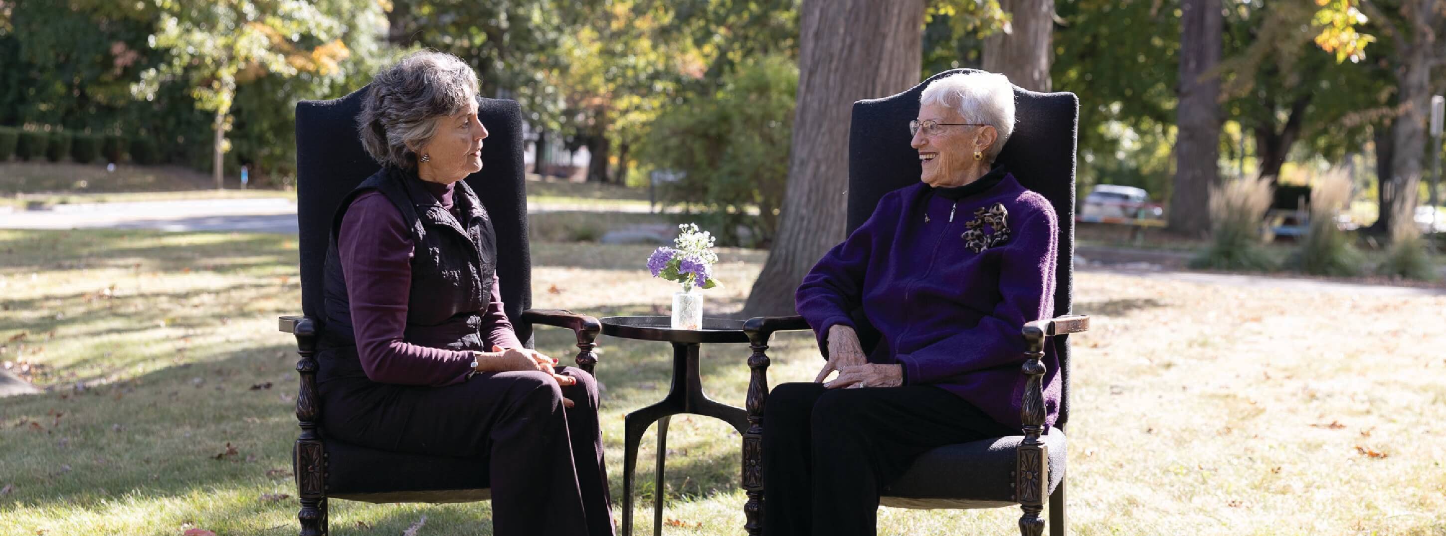 Two elderly sitting outside having a discussion