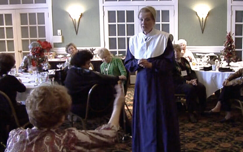 woman dressed as a pilgrim in character at a senior women's event