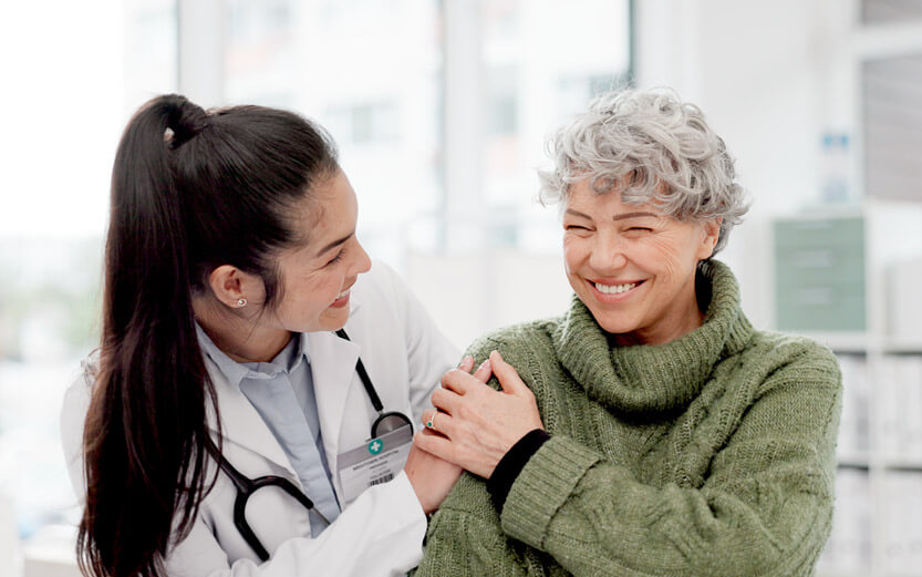 a doctor reassuring a patient who is smiling