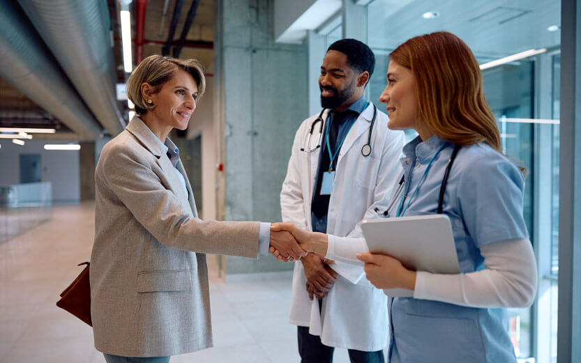 two doctors greeting a woman