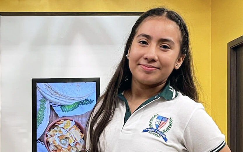 academy student smiling wearing shirt with school logo