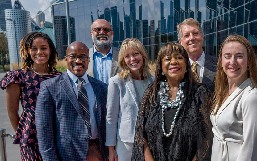 a group shot of people in business attire standing outside