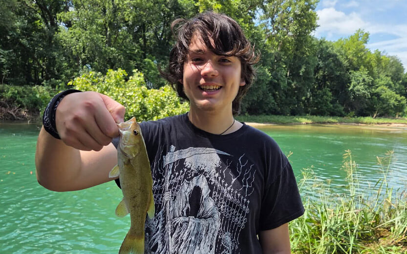 young boy holding a fish