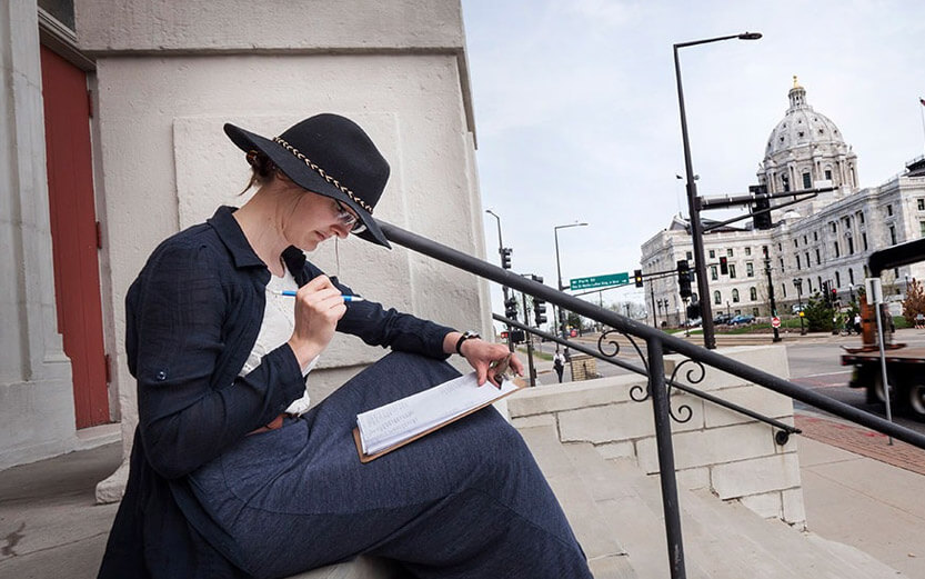 woman studying on building steps