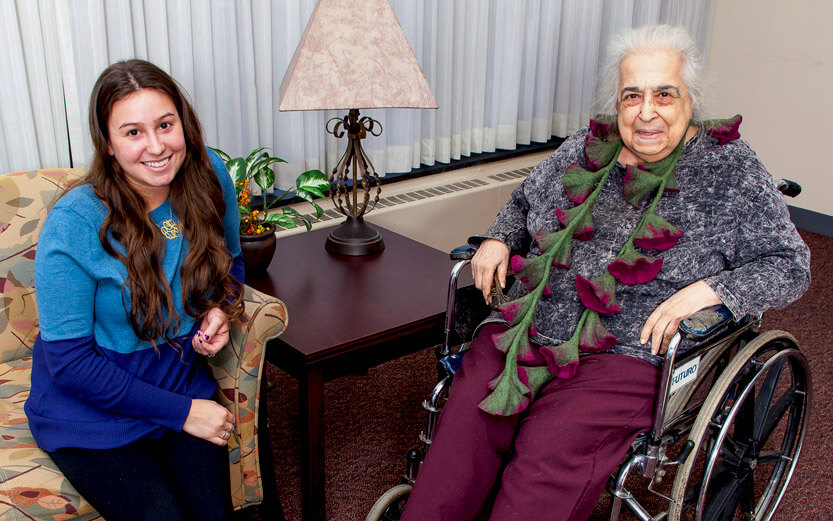 volunteer sitting with woman in wheelchair