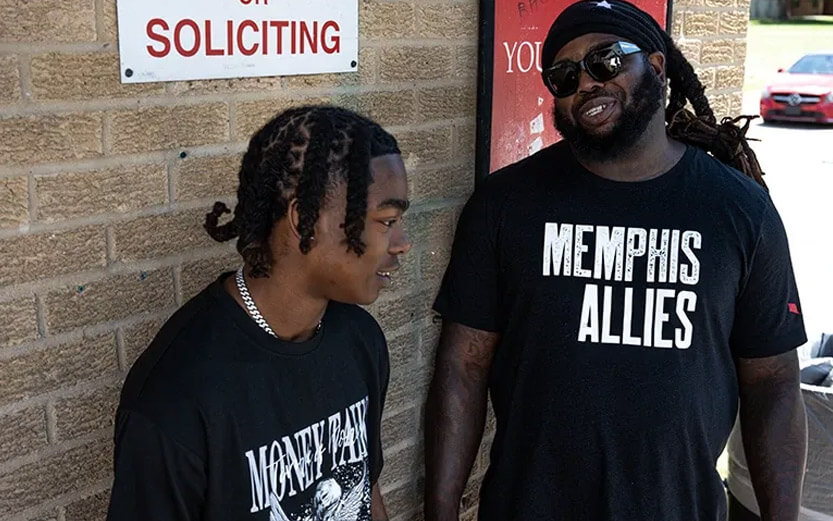 two men wearing black tshirts talking