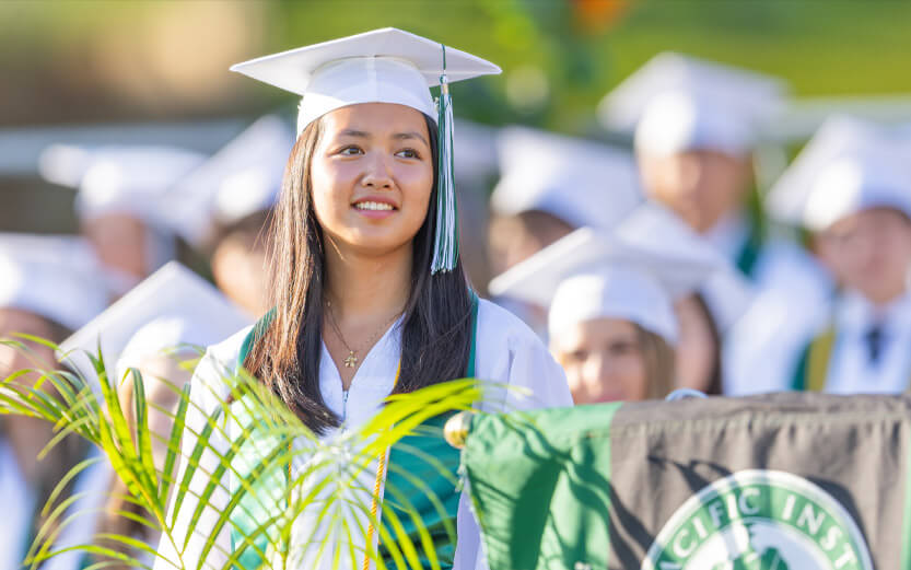 student wearing cap and gown at graduation