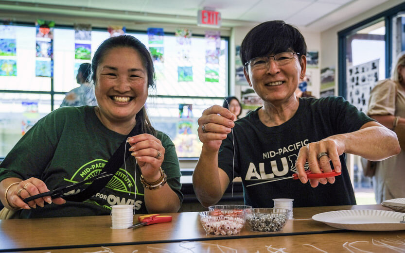 two people doing a bead stringing craft