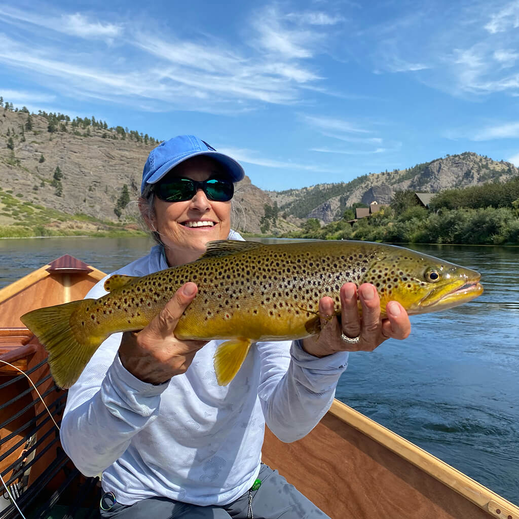 Kris Spanjian holding a large, beautifully spotted brown trout