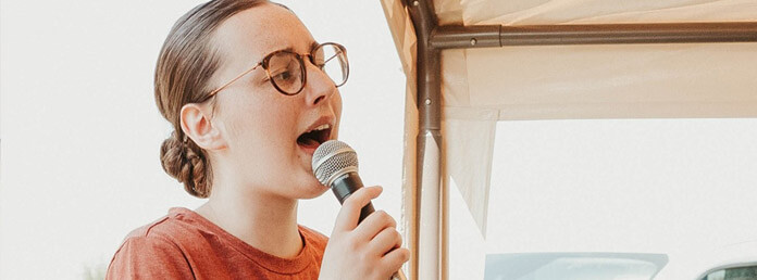 woman with glasses singing outside