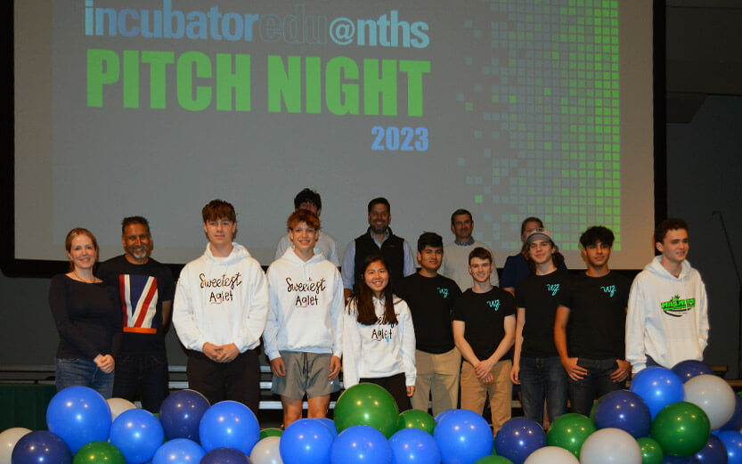 students on stage with a projection behind them for Pitch Night