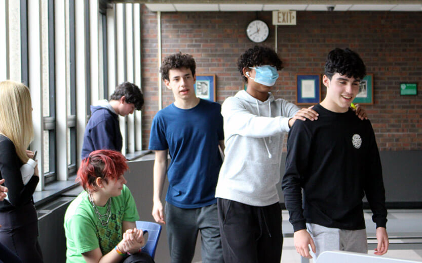 students doing an activity where one person leads another who is blindfolded