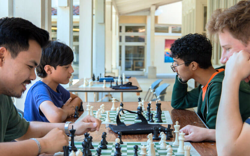 four people playing chess