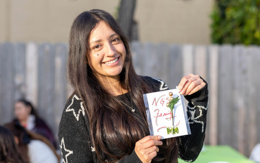 a student holding a card that says NGS Family