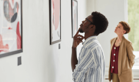 A museum patron observing art on the wall