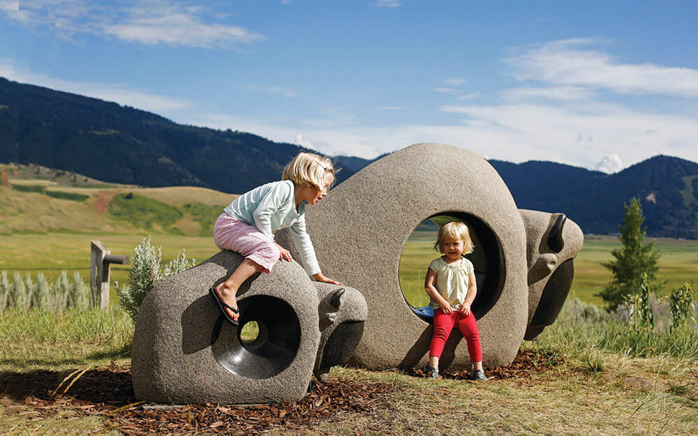 2 children climbing on sculptures