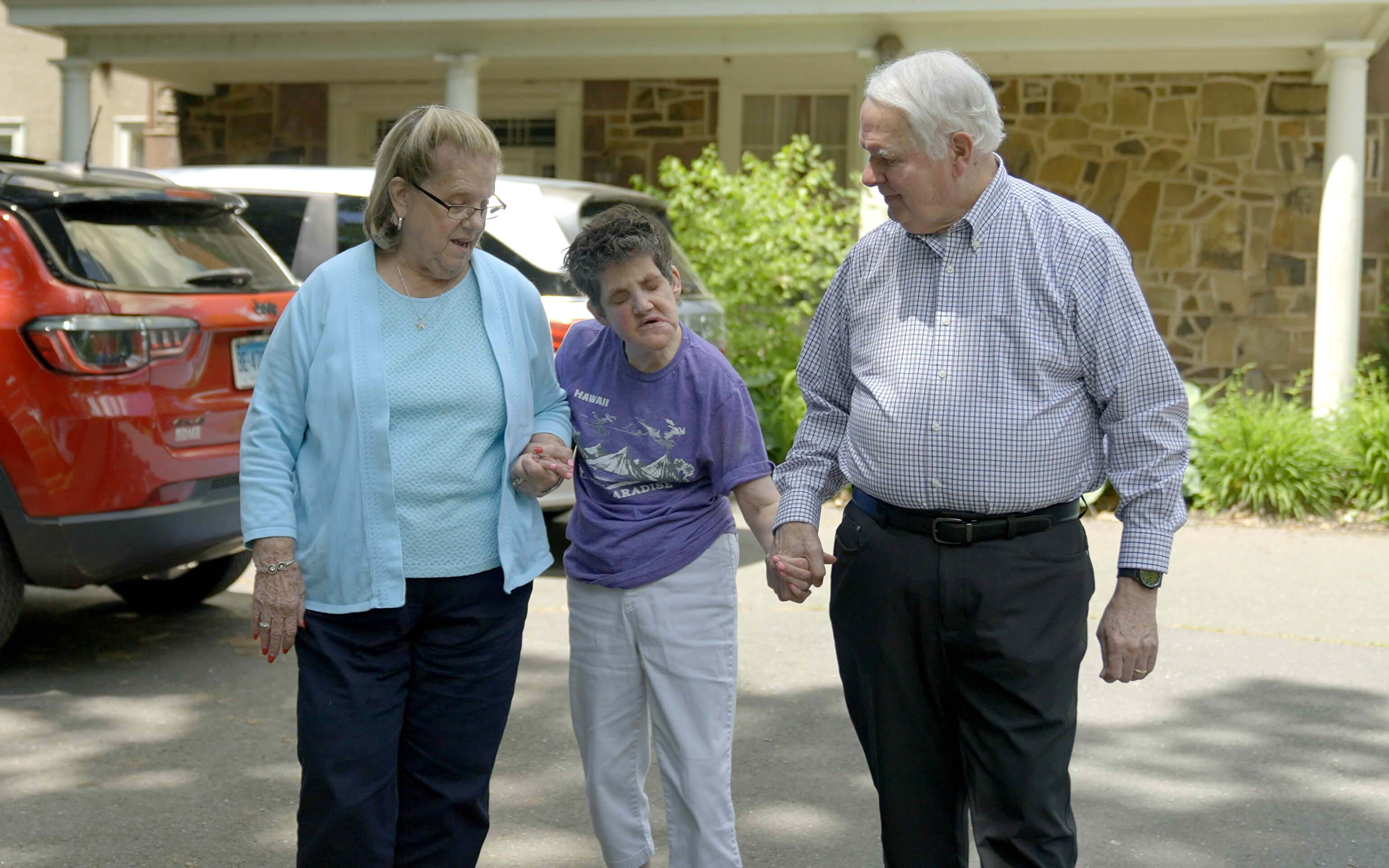 senior couple holding hands with a visually impaired person