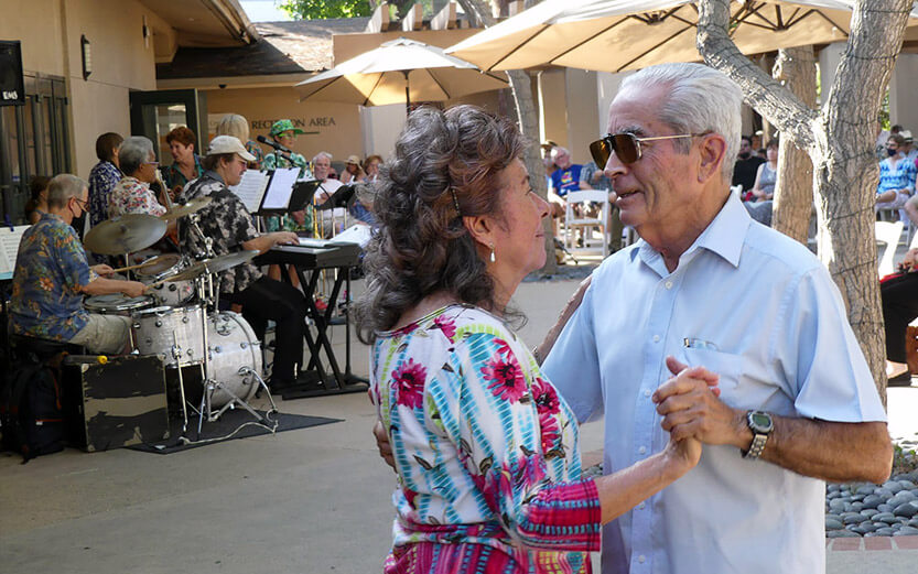 a senior couple dancing outdoors