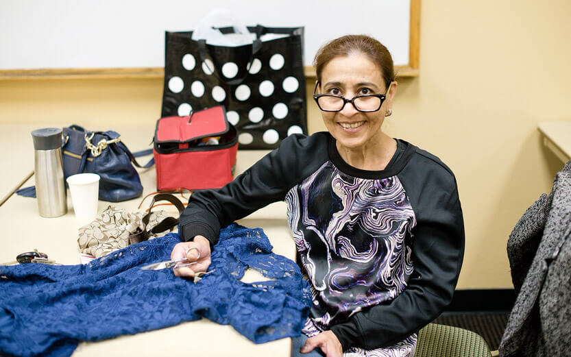 a woman sewing a blue garment