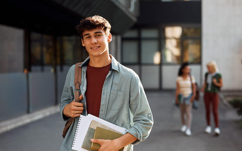 student with notebooks
