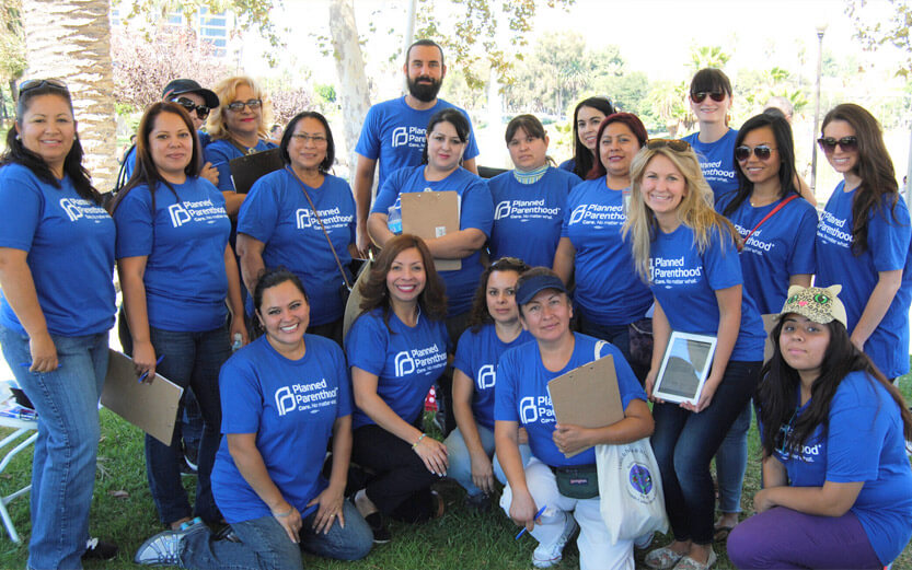 a group of Planned Parenthood working wearing blue t-shirts pose for a group photo