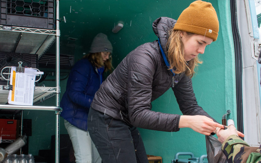 volunteers in the back of a van handing out food