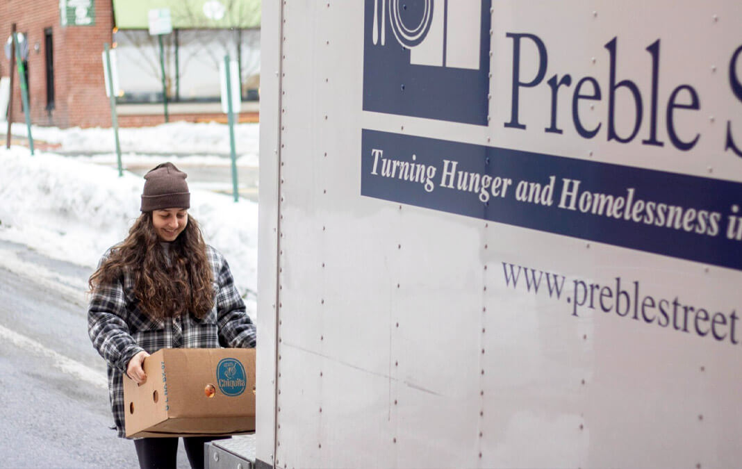 volunteer loading a truck with boxes of food