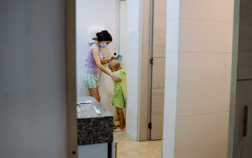 a mother helps her child dry off after a shower